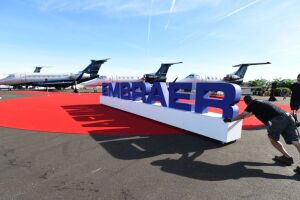 Funcionários ajeitam letreiro da Embraer (EMBR3) durante exposição em Las Vegas