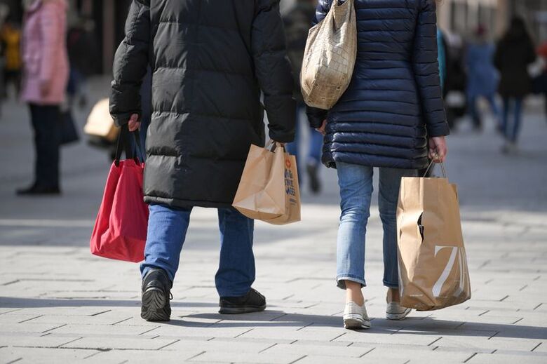 Consumidores carregam sacolas com compras em rua de Munique, Alemanha, em 08/03/2021 