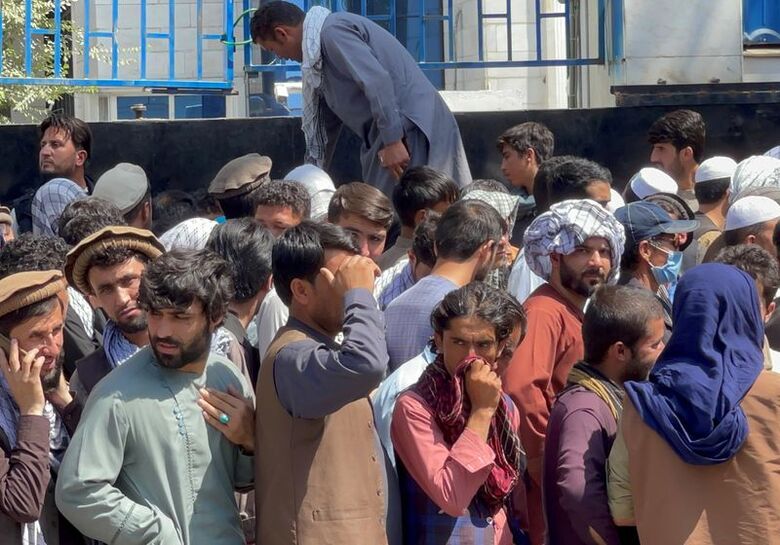 Afegãos fazem fila para sacar dinheiro em agência bancária em Cabul