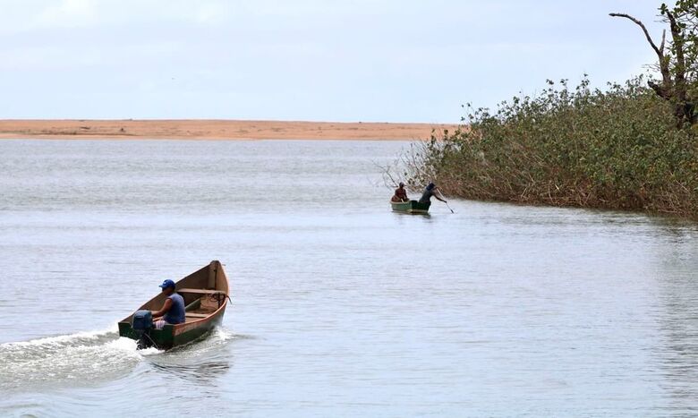 Pescadores navegam pelo Rio Doce